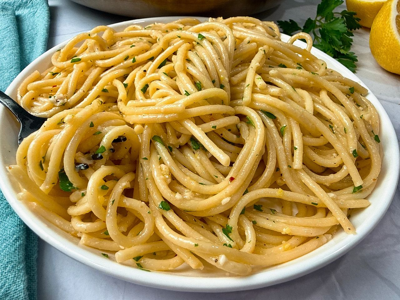 Lemon Garlic Pasta in a white bowl with a black fork