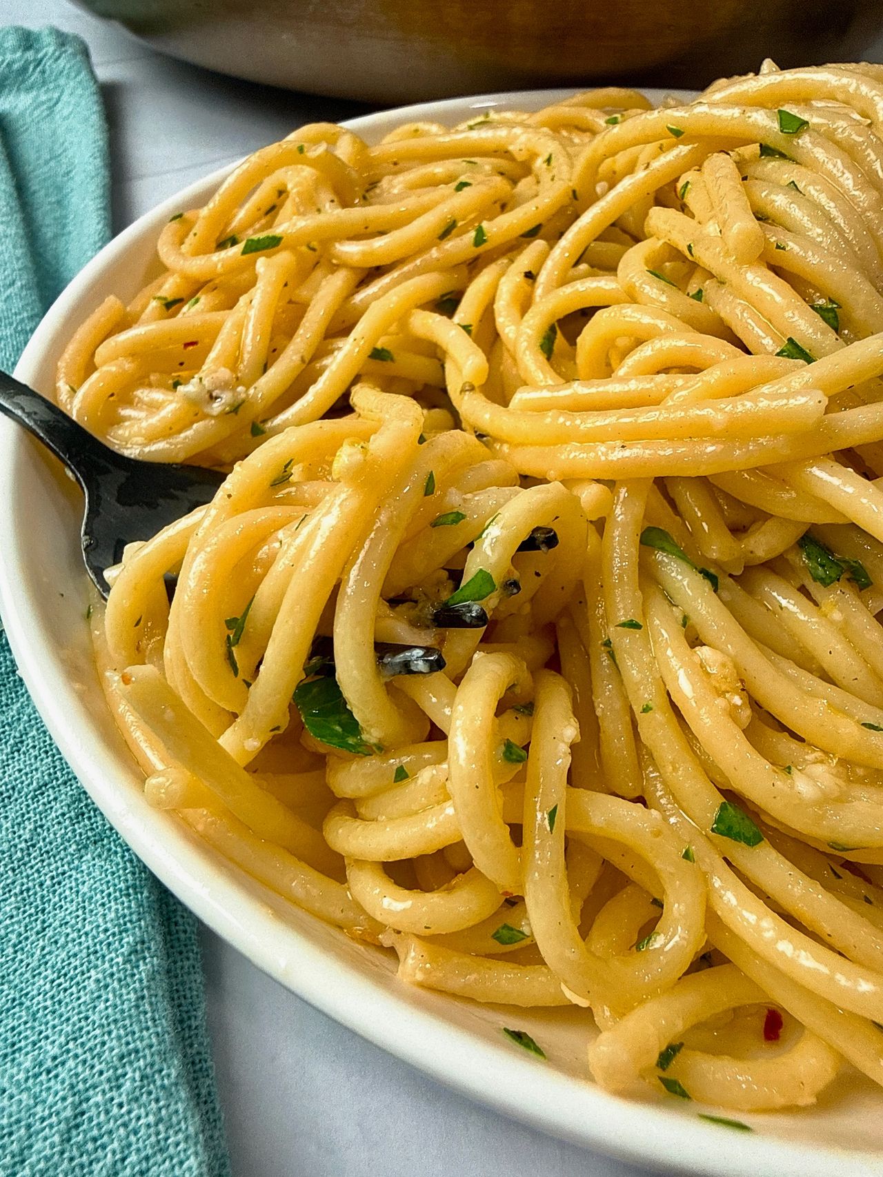 Lemon Garlic Pasta in a white bowl with a black fork