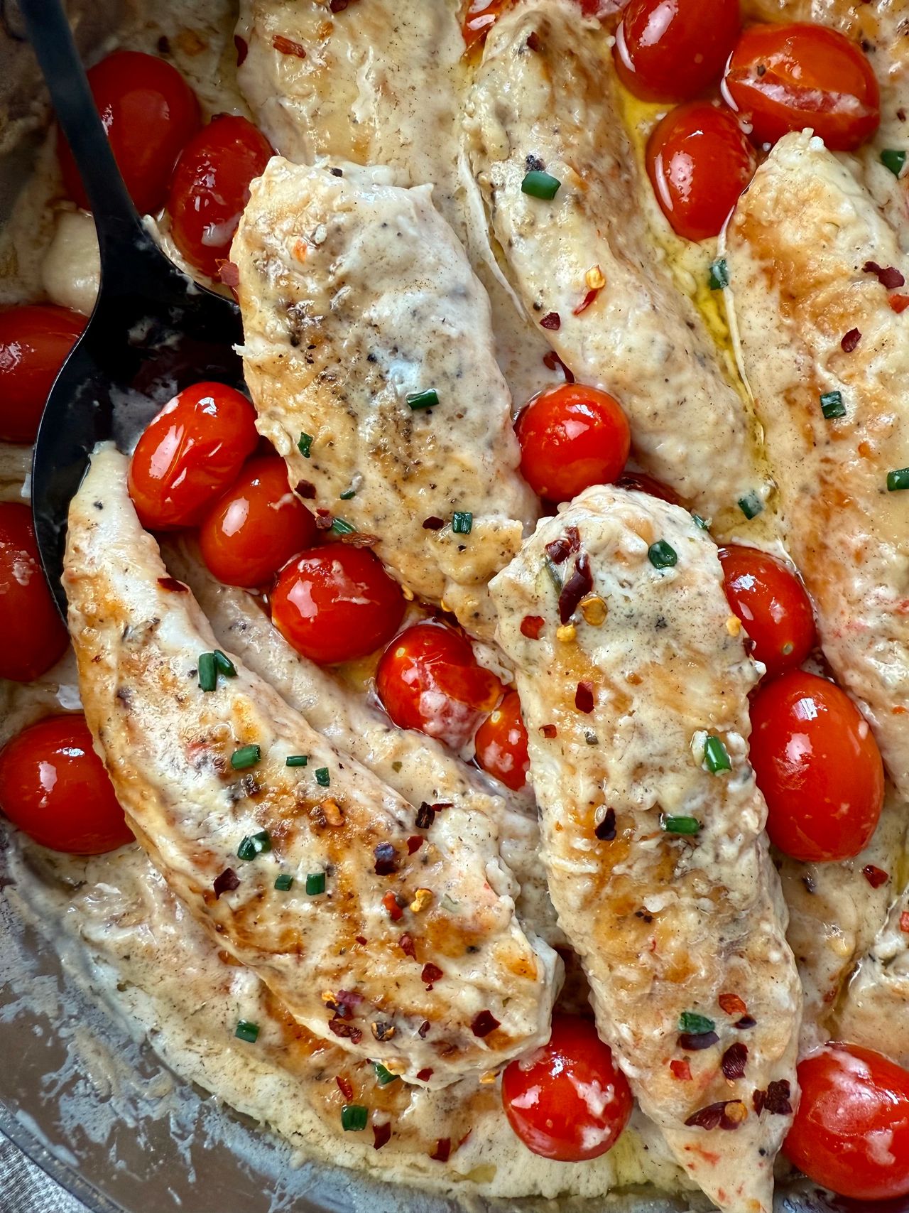 Boursin Chicken in a skillet with grape tomatoes