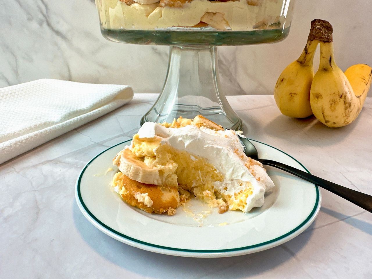 Banana Pudding in a tall clear dessert bowl and on a white dessert plate