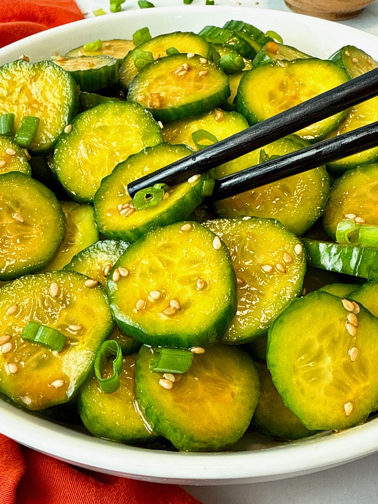 Asian Cucumber Salad in a white bowl with black chop sticks