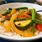 Spring Vegetable Stir Fry in a shallow bowl with a fork