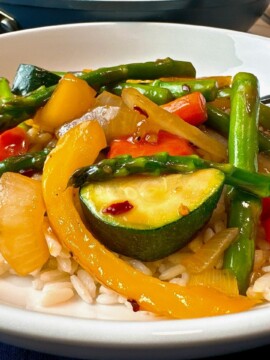 Spring Vegetable Stir Fry in a shallow bowl with a fork