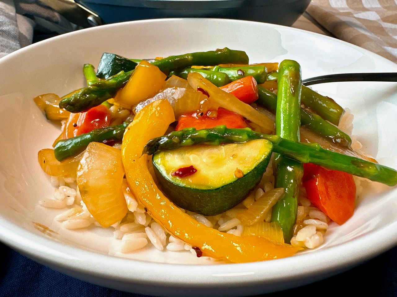 Spring Vegetable Stir Fry in a shallow bowl with a fork