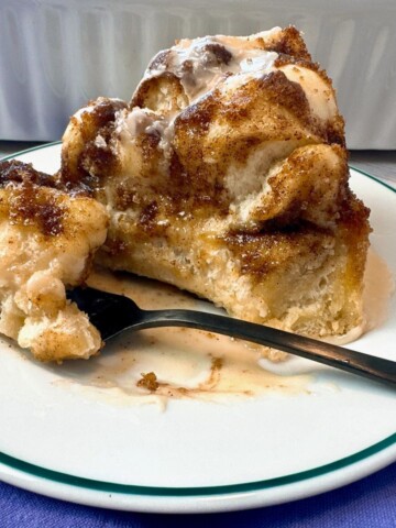 Cinnamon Roll Focaccia in a white baking dish and on a dessert plate with a fork