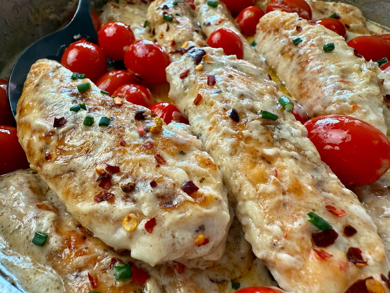 Boursin Chicken in a skillet with grape tomatoes
