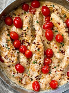 Boursin Chicken in a skillet with grape tomatoes