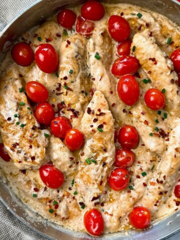 Boursin Chicken in a skillet with grape tomatoes