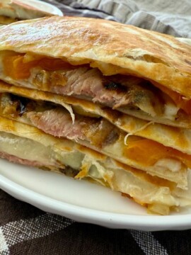 Philly Cheesesteak Quesadillas stacked on a white plate