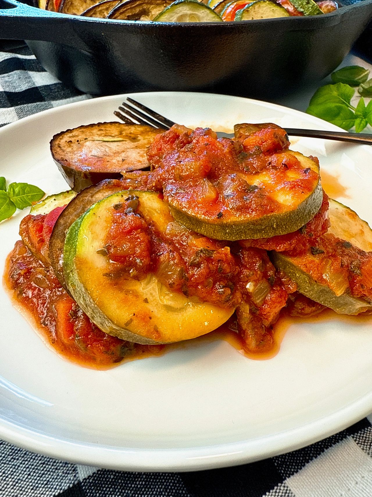 Ratatouille on a white plate with a black fork