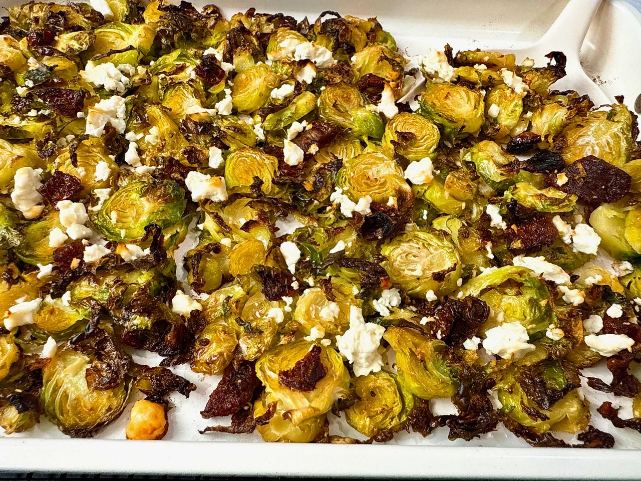 Roasted Shaved Brussels Sprouts with Feta on a white baking pan