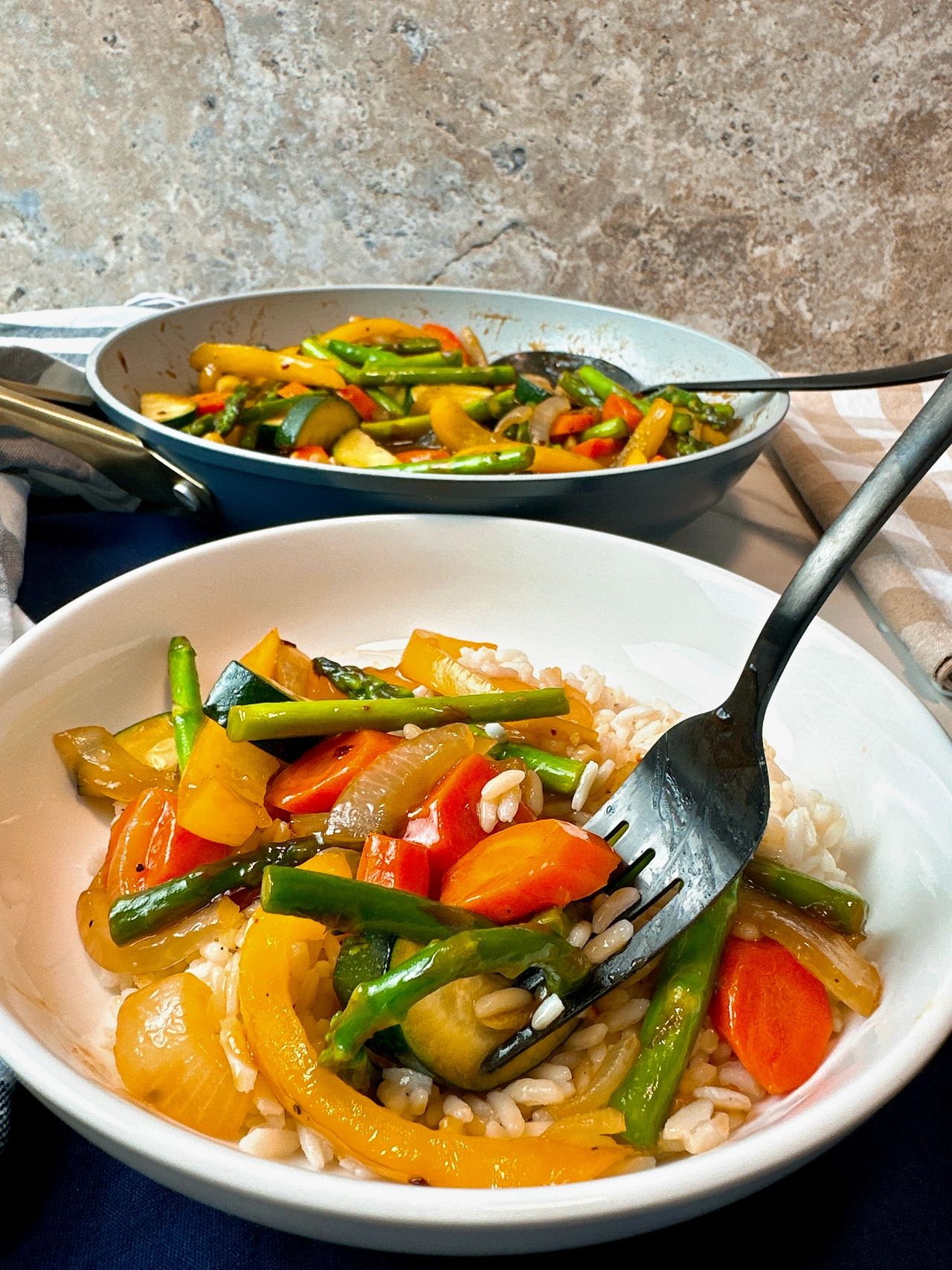 Spring Vegetable Stir Fry in a shallow bowl with a fork