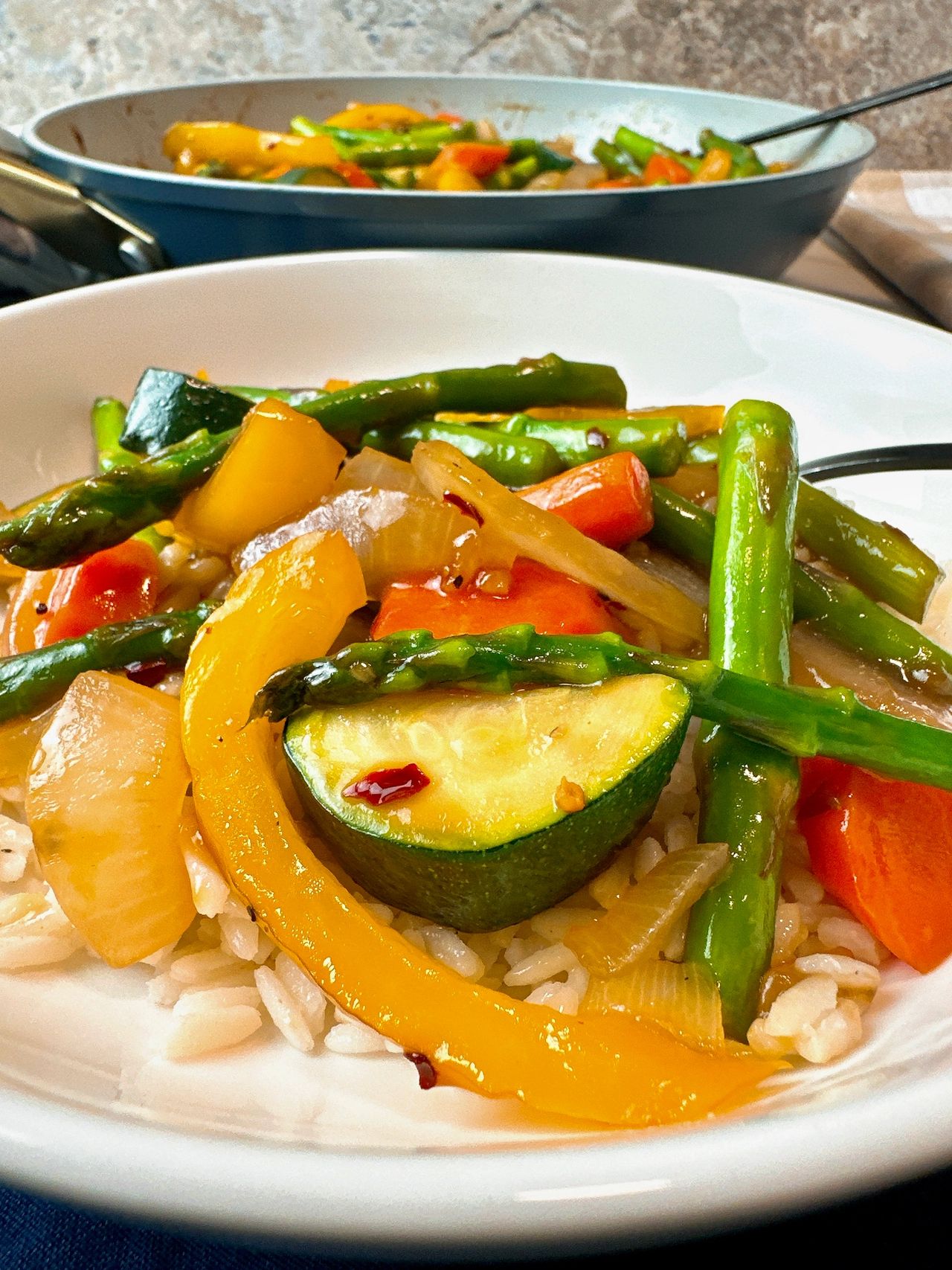 Spring Vegetable Stir Fry in a shallow bowl with a fork