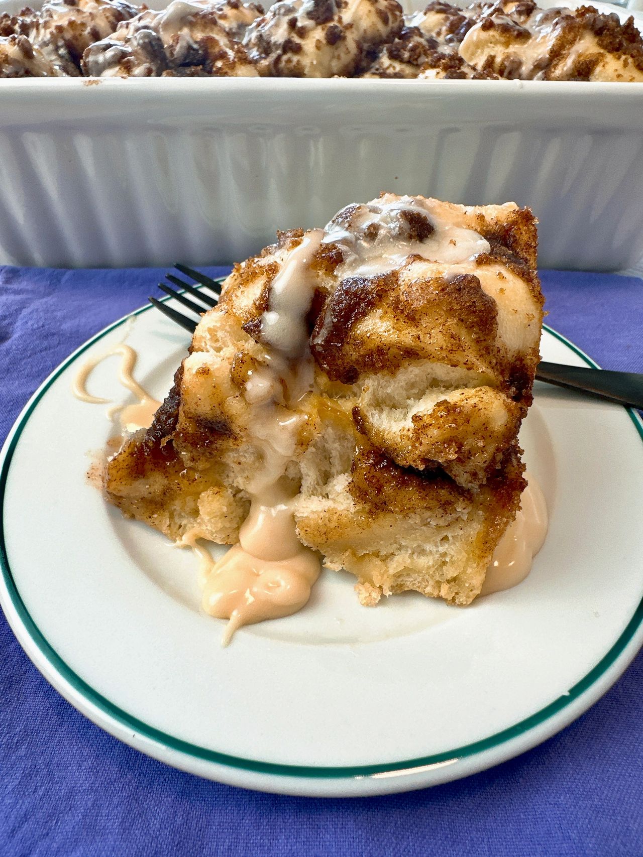 cinnamon roll focaccia on a white plate with a black fork