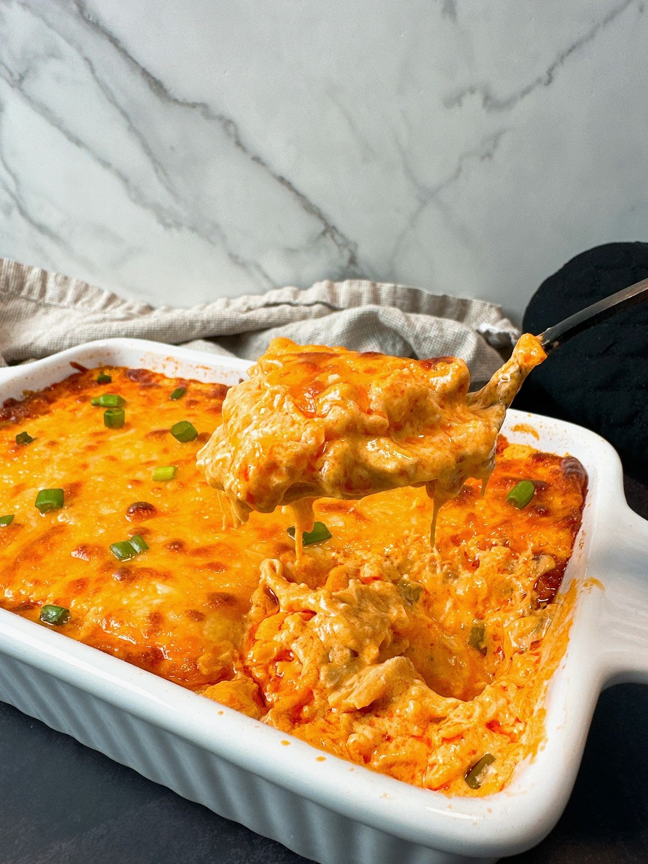 Buffalo Chicken Dip in a white dish and on a black spoon