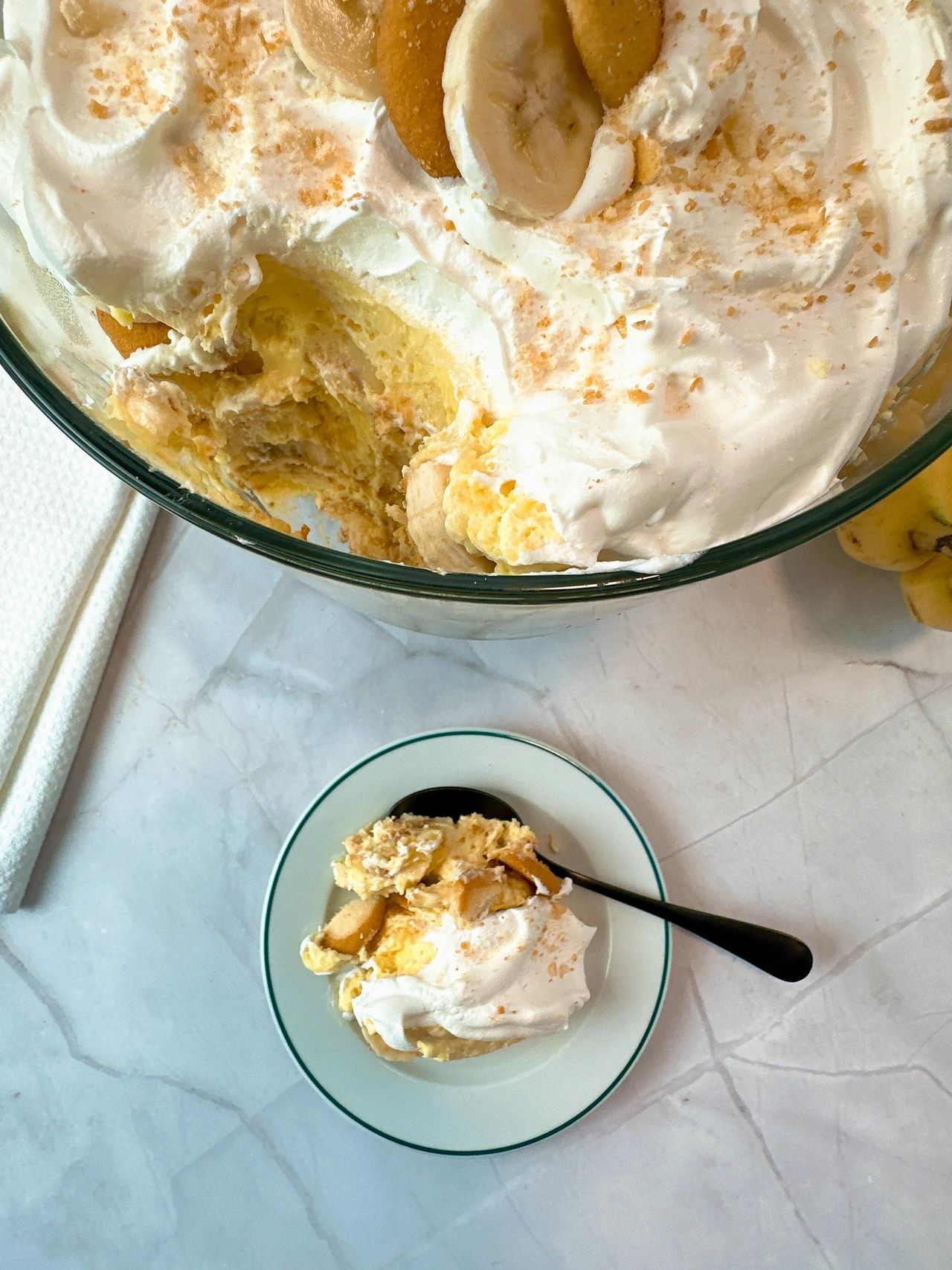 Banana Pudding in a tall clear dessert bowl and on a white dessert plate