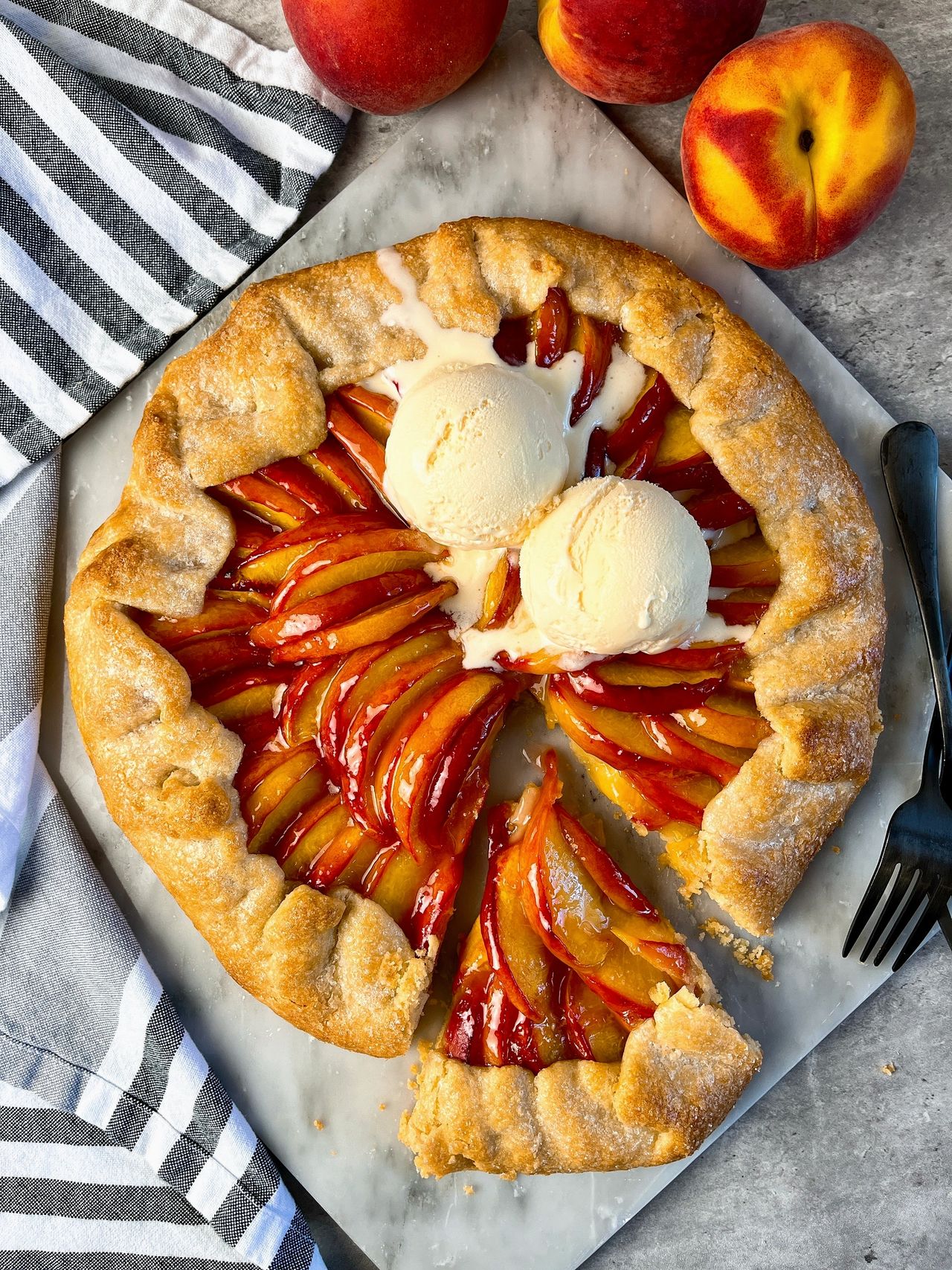Easy Peach Galette on a marble surface with scoops of vanilla ice cream