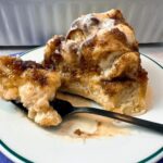 Cinnamon Roll Focaccia in a white baking dish and on a dessert plate with a fork