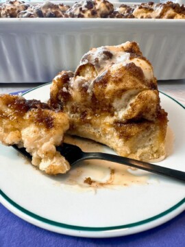 Cinnamon Roll Focaccia in a white baking dish and on a dessert plate with a fork