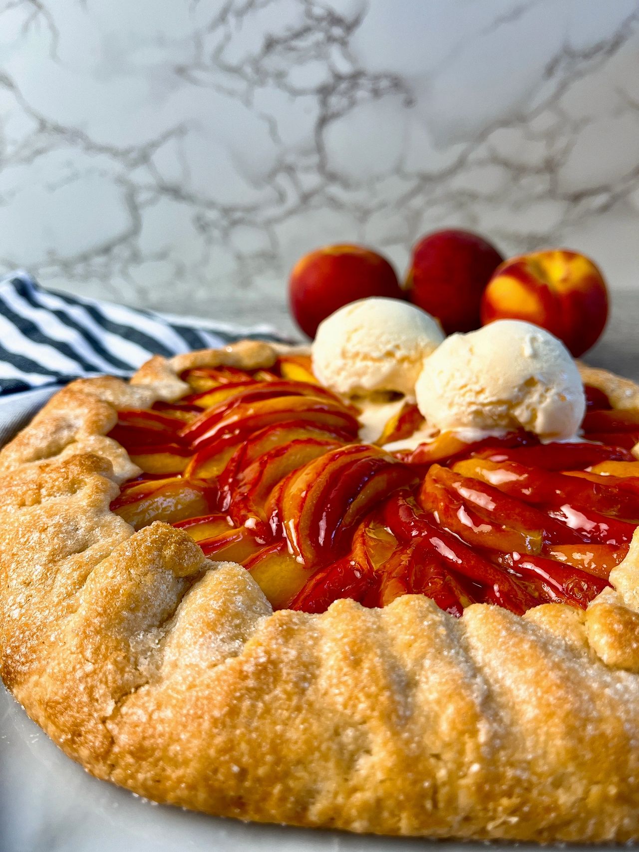 Easy Peach Galette with vanilla ice cream and peaches in the background