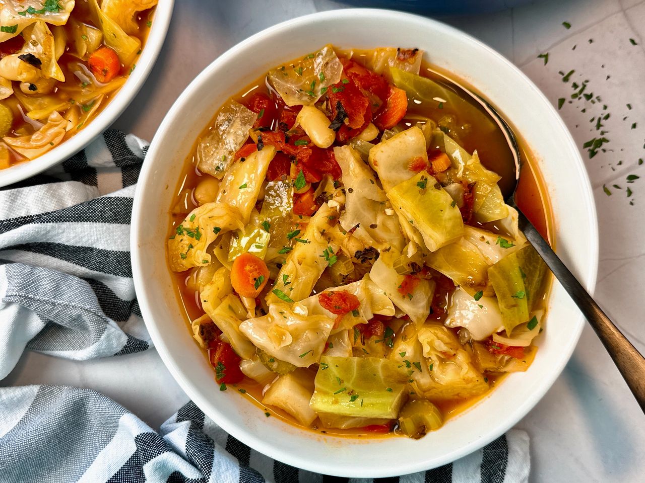 Cabbage Soup in a white bowl with a black spoon 