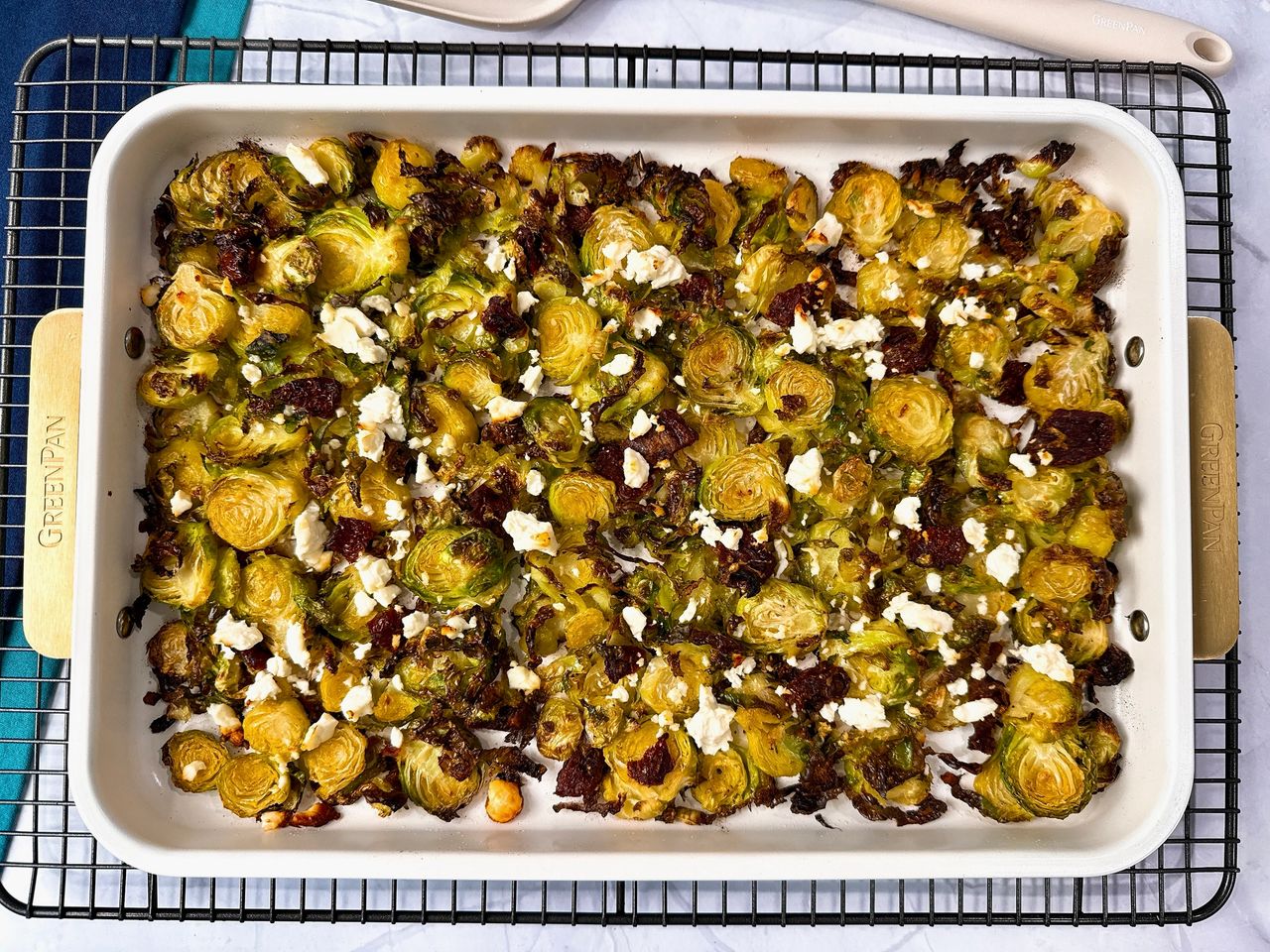 Roasted Shaved Brussels Sprouts with Feta on a white baking pan on a wire rack
