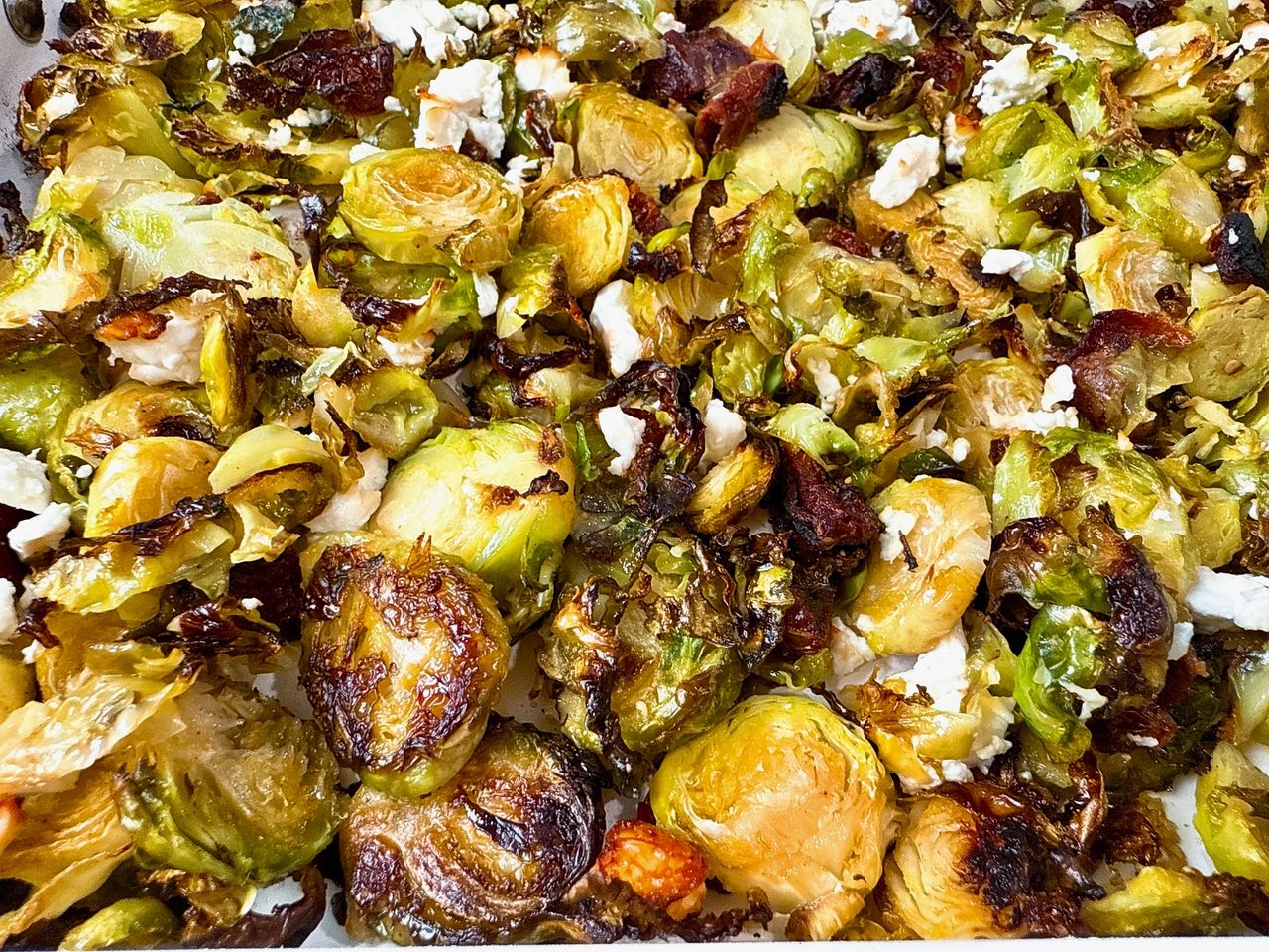 Roasted Shaved Brussels Sprouts with Feta on a white baking pan