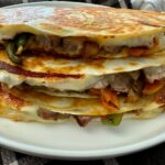 Philly Cheesesteak Quesadillas stacked on a white plate