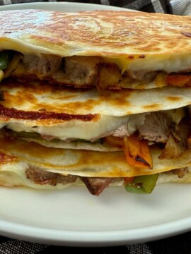 Philly Cheesesteak Quesadillas stacked on a white plate
