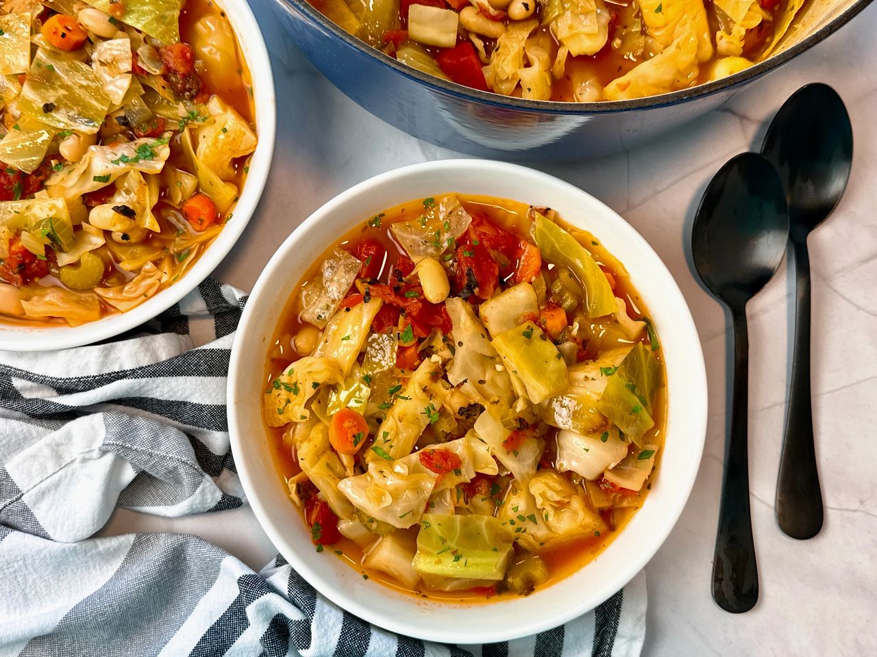 Cabbage Soup in a white bowls with black spoons