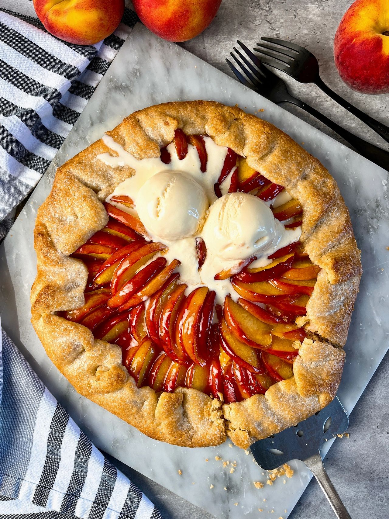 Easy Peach Galette on a marble surface with scoops of vanilla ice cream
