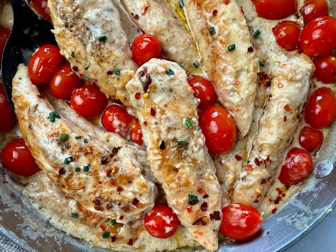 Boursin Chicken in a skillet with grape tomatoes