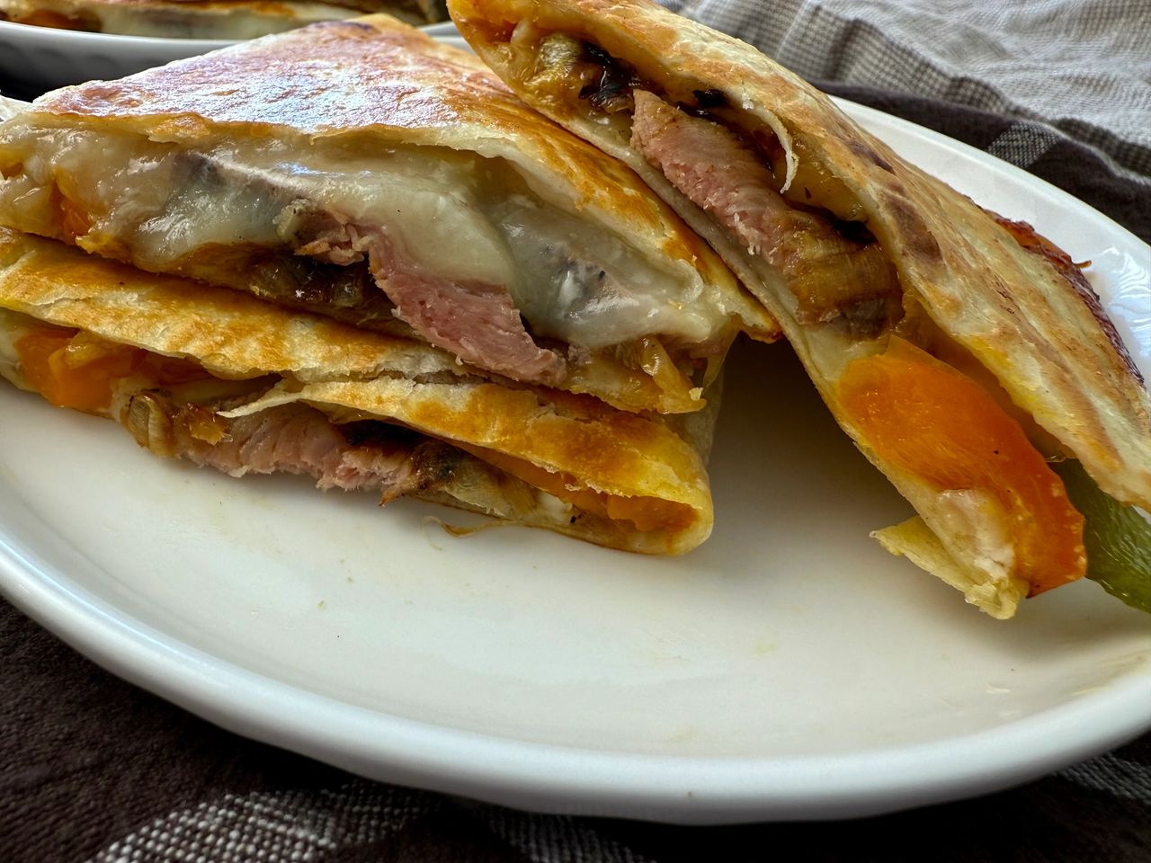 Philly Cheesesteak Quesadillas stacked on a white plate
