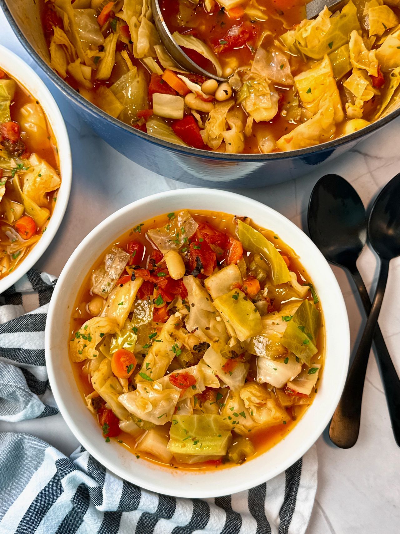 Cabbage Soup in a white bowl with a black spoon 