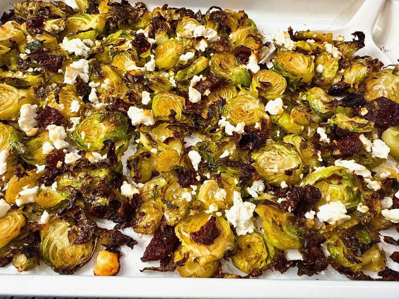 Roasted Shaved Brussels Sprouts with Feta on a white baking pan