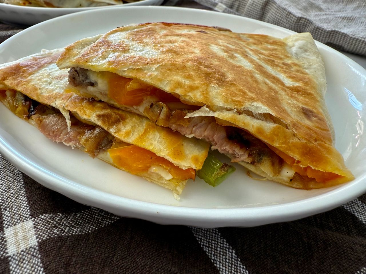 Philly Cheesesteak Quesadillas stacked on a white plate