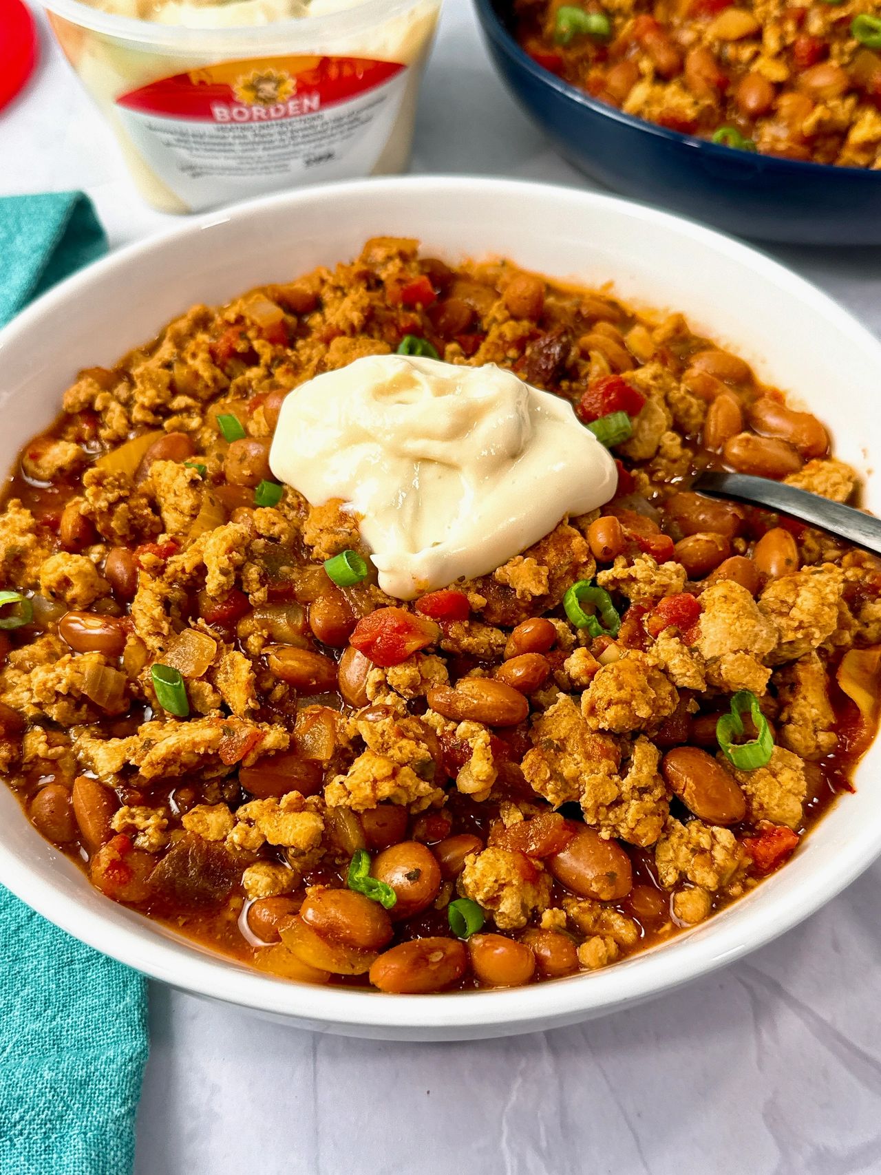 chicken chili ini a white bowl with a spoon