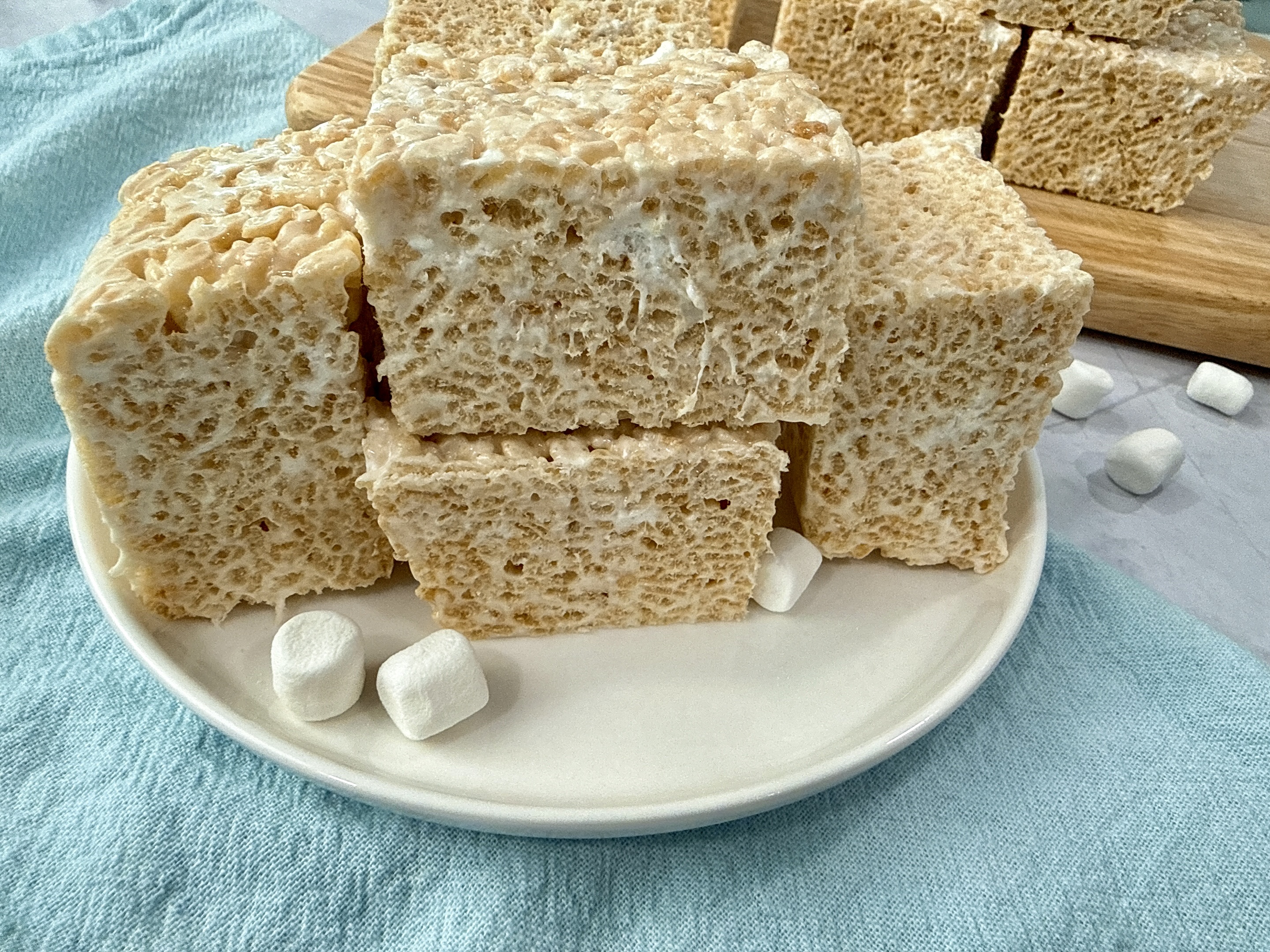 rice krispie treats on a white plate with mini marshmallows
