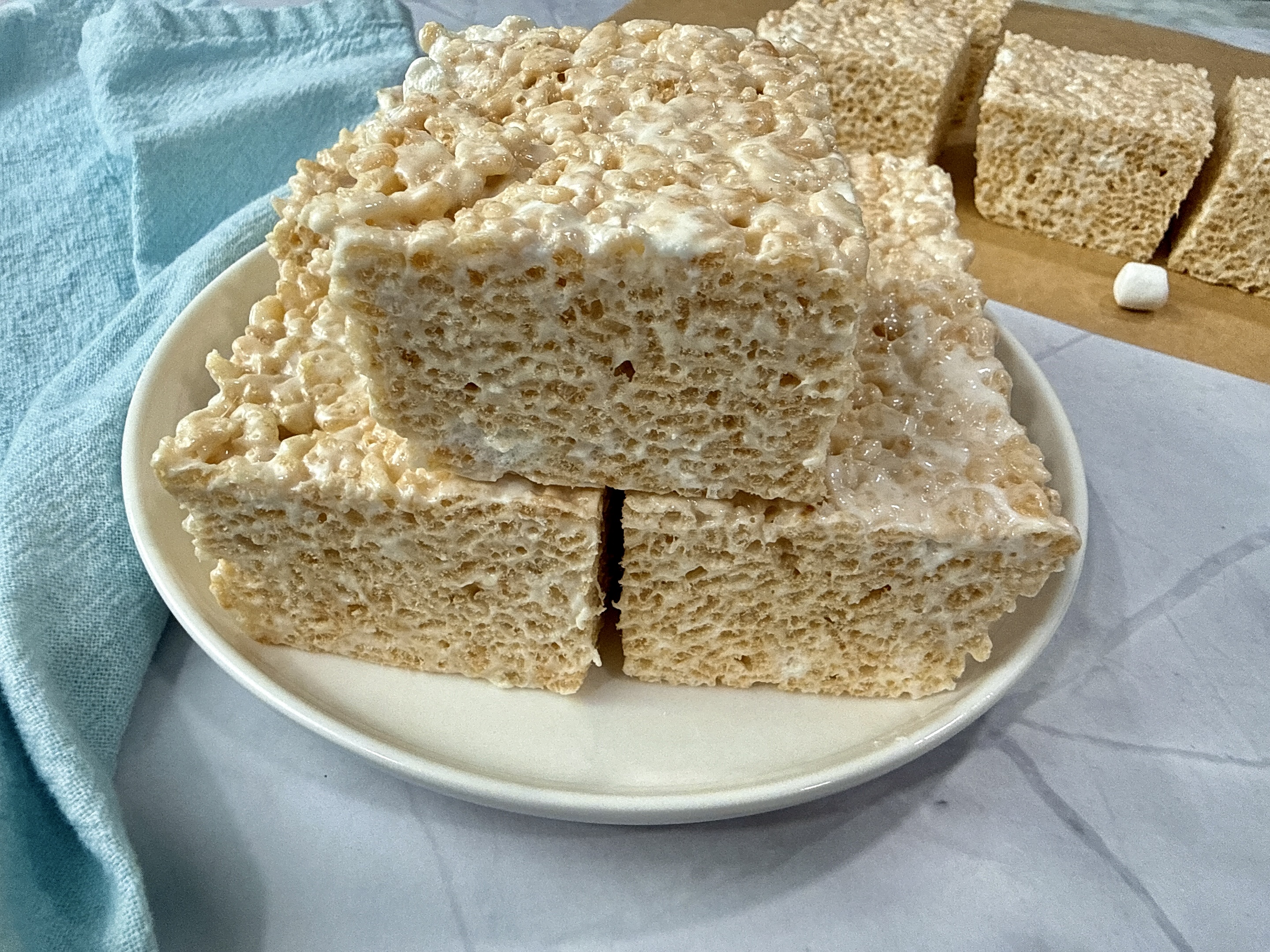 rice krispie treats on a white plate with mini marshmallows