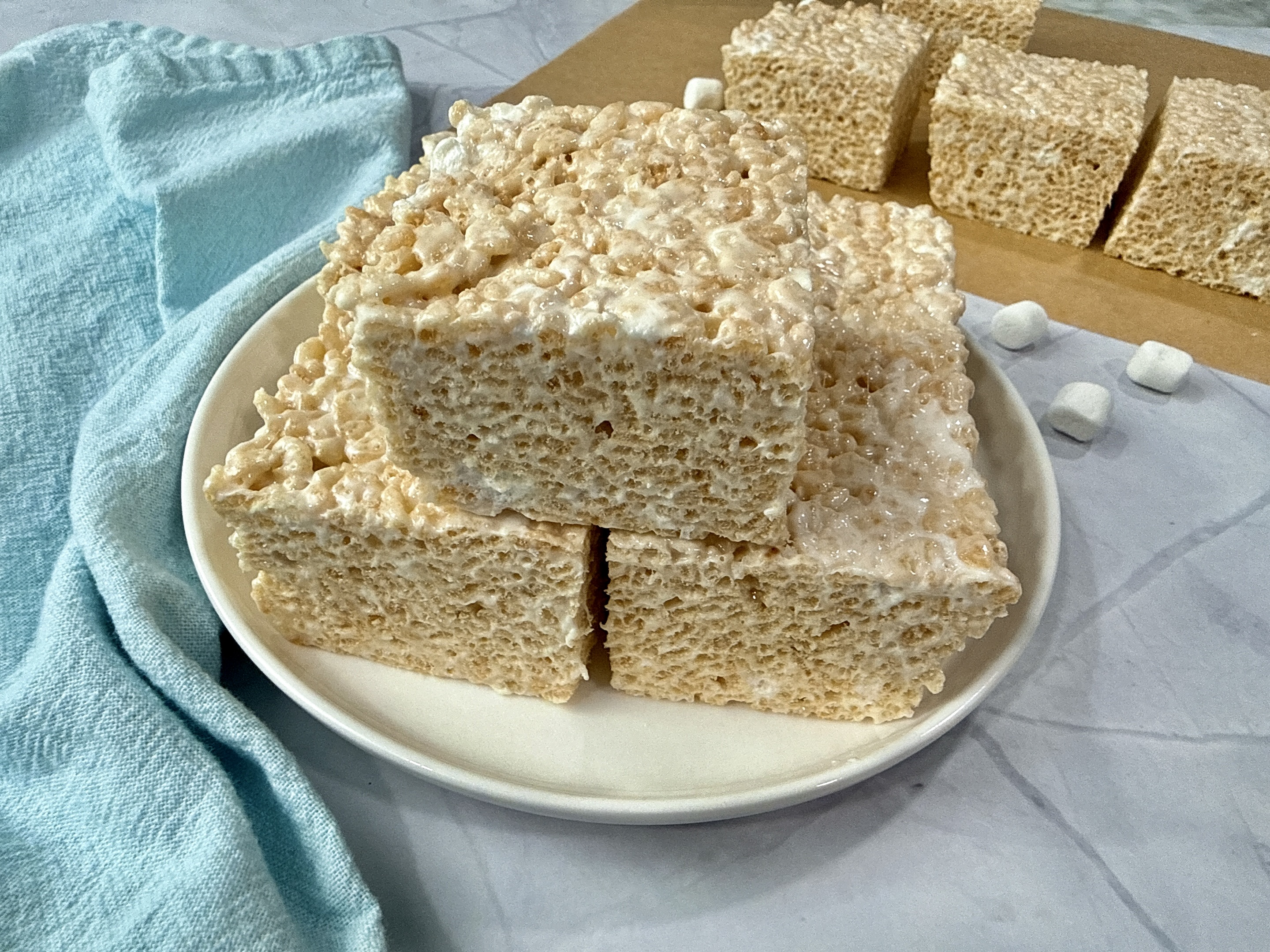 rice krispie treats on a white plate with mini marshmallows