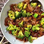 beef and broccoli in a white skillet