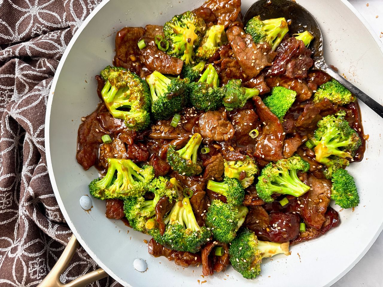 beef and broccoli in a white skillet