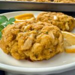 crab cakes and lemon slices on a white plate