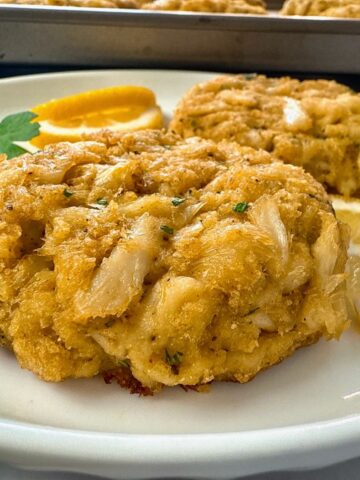 crab cakes and lemon slices on a white plate