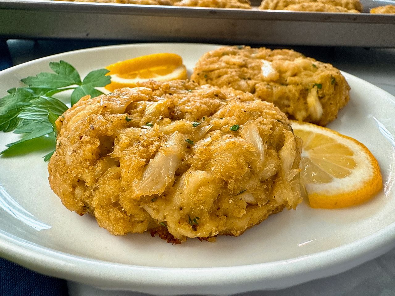 crab cakes and lemon slices on a white plate