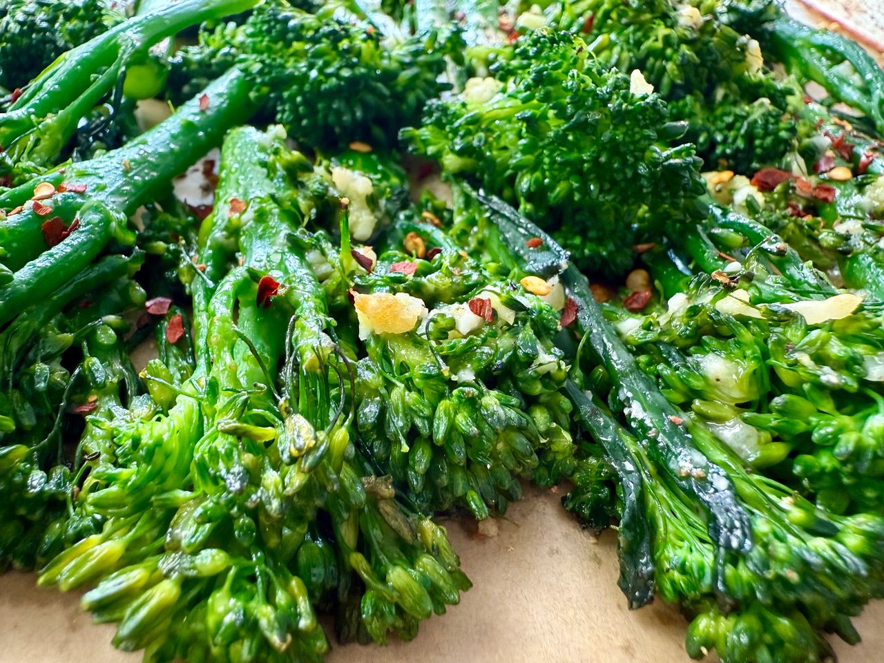 broccolini and red pepper flakes on a parchment paper lined baking sheet