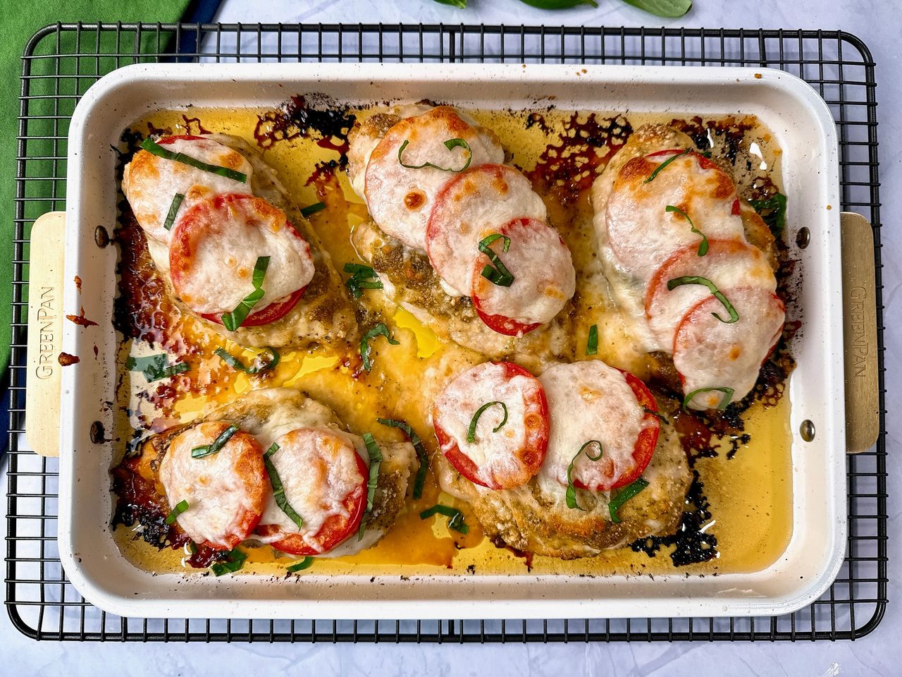 baked chicken with cheese and tomatoes on a white plate