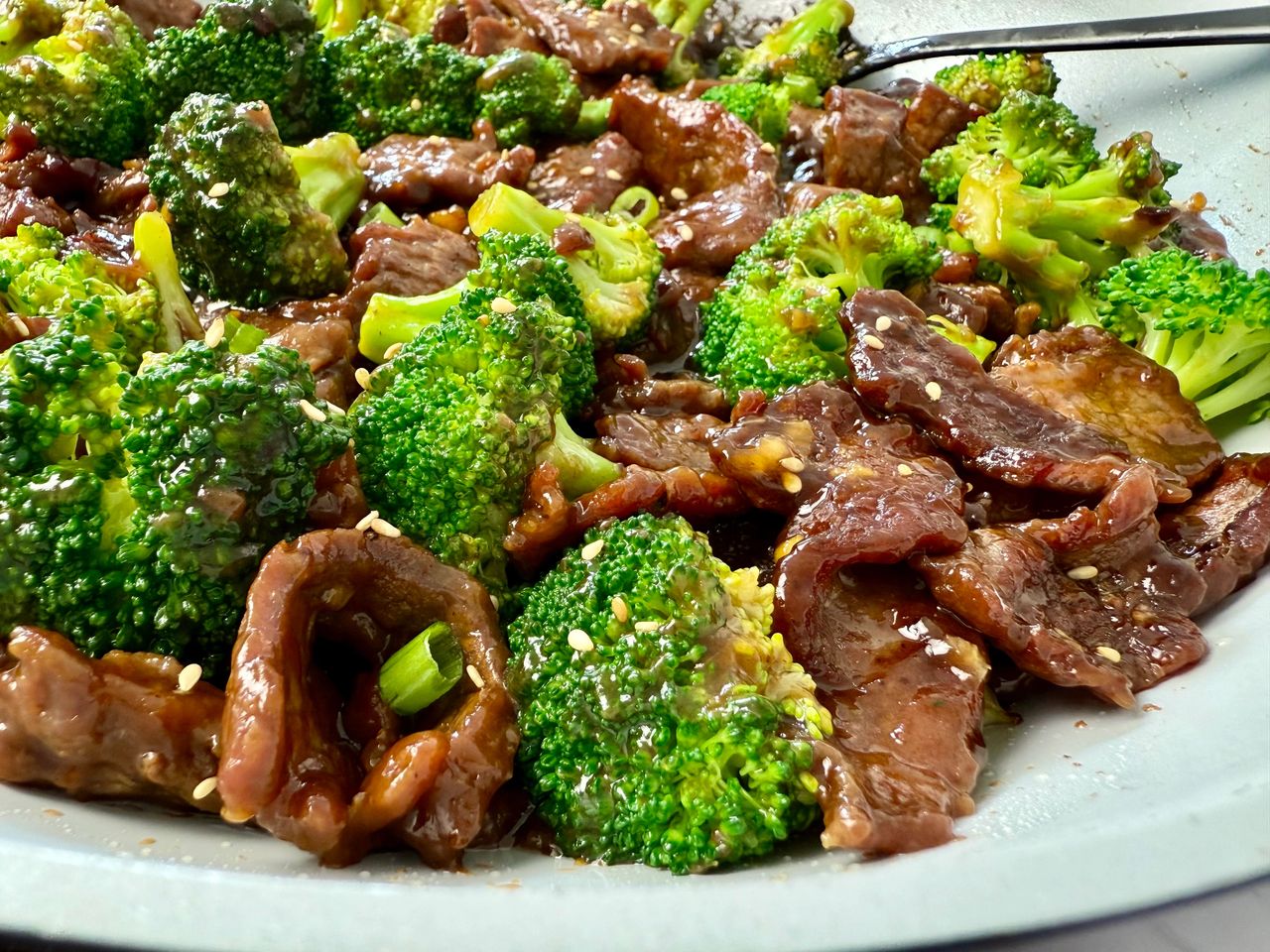 beef and broccoli in a white skillet