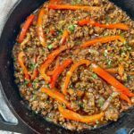 ground beef and peppers in a cast iron skillet