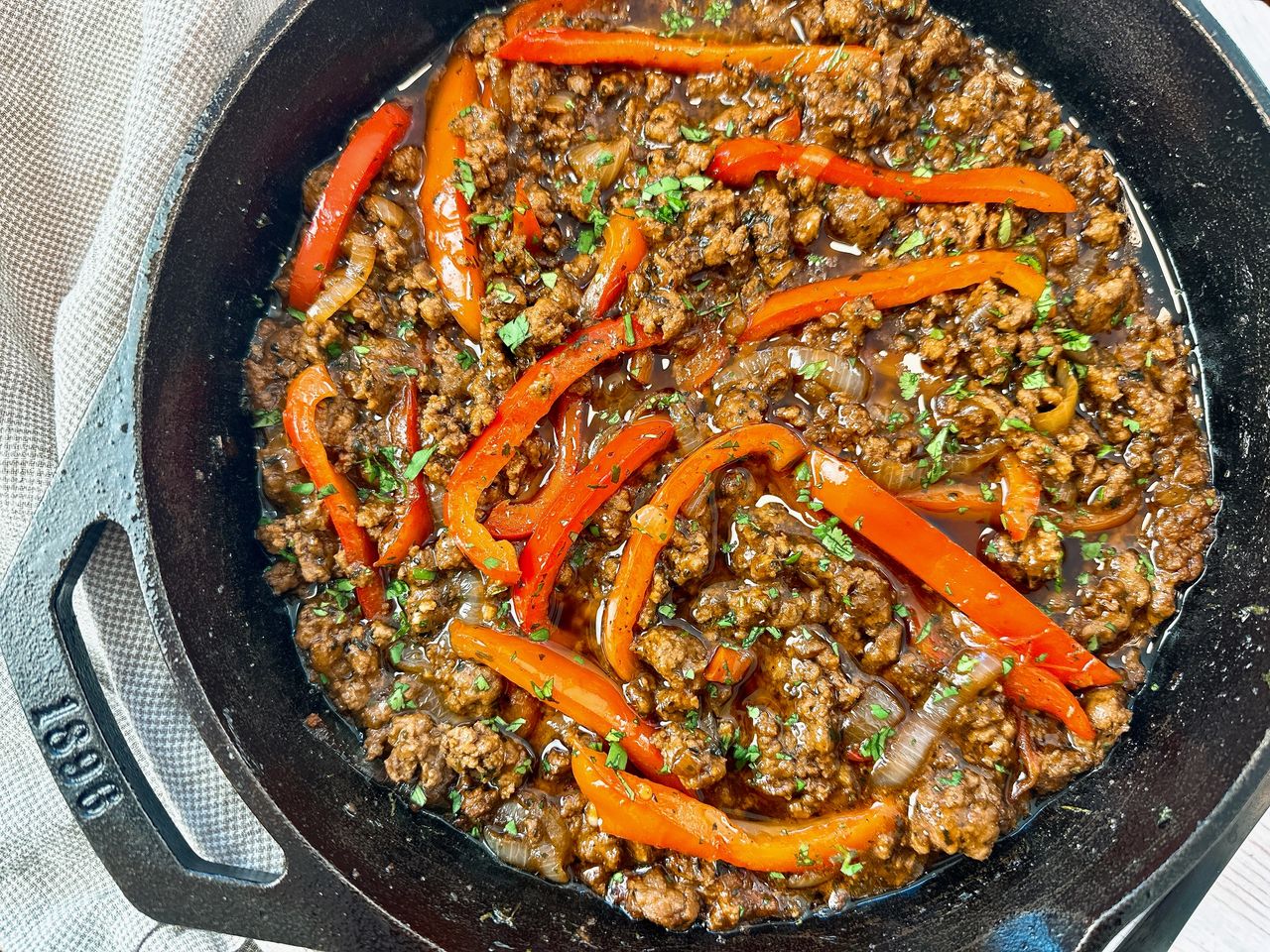 ground beef and peppers in a cast iron skillet